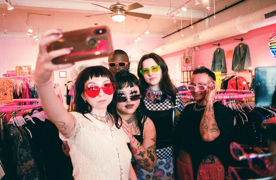 Inside EMOTE on Haywood Road, hot pink walls and racks with customers taking a selfie