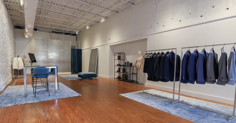 The Raleigh showroom on Blake Street, exposed brick with rolling racks of suit jackets