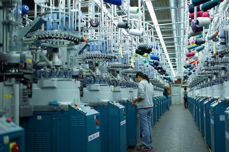 The knitting hall at Harriss and Covington in High Point, an aisle of sock knitting machines